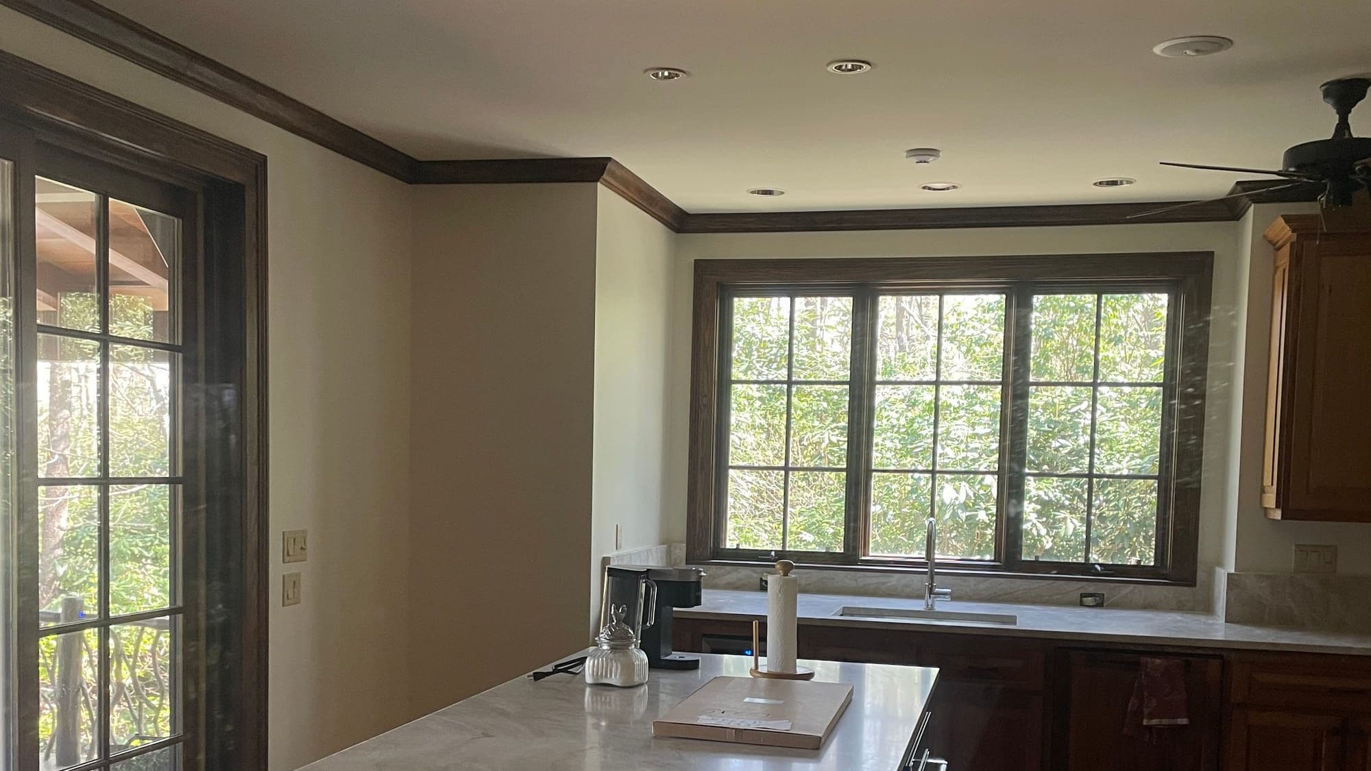 Kitchen and living area with freshly painted walls and trim by TJ Pro Painting